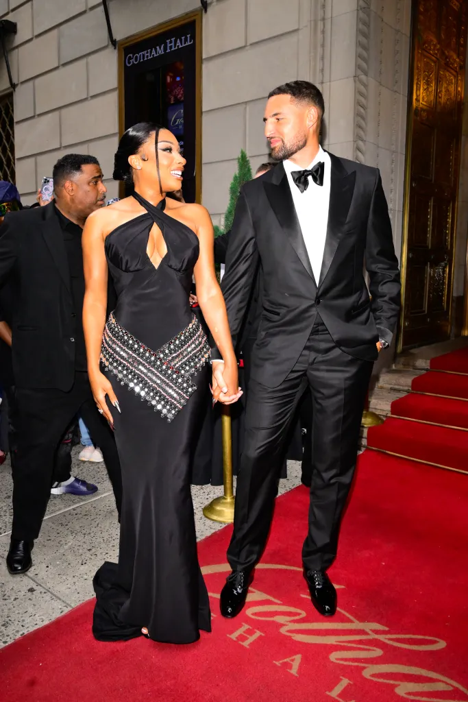 Megan Thee Stallion and Klay Thompson holding hands on a red carpet.