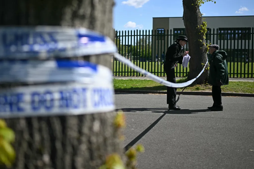A police officer speaks to a man behind a 
