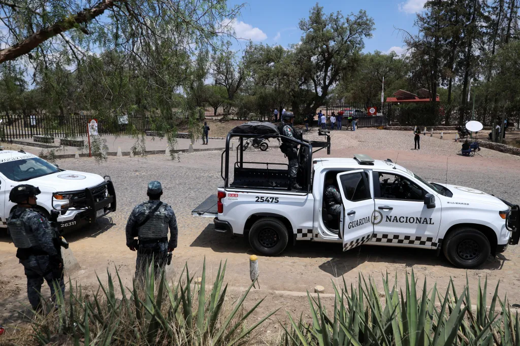 National Guard officers stand near two patrol trucks outside the Teotihuacan pyramids following a shooting.