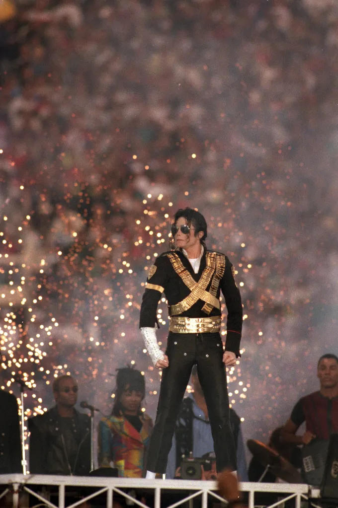 Michael Jackson performs during the Super Bowl XXVII Halftime Show, with pyrotechnics in the background.
