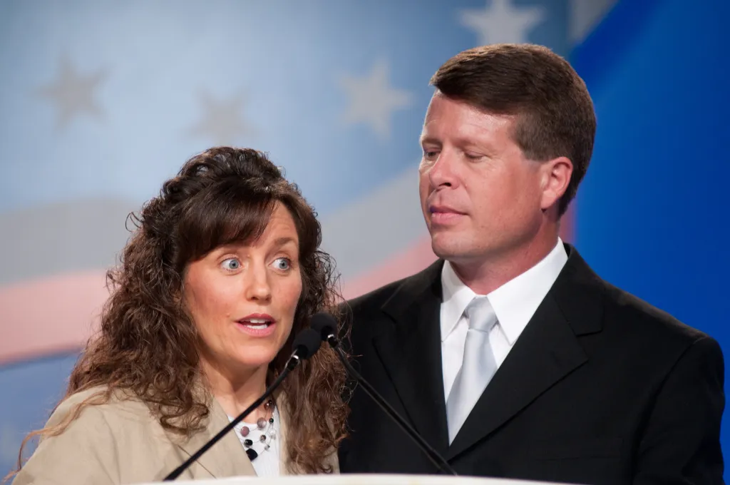 Michelle and Jim Bob Duggar speaking at microphones.