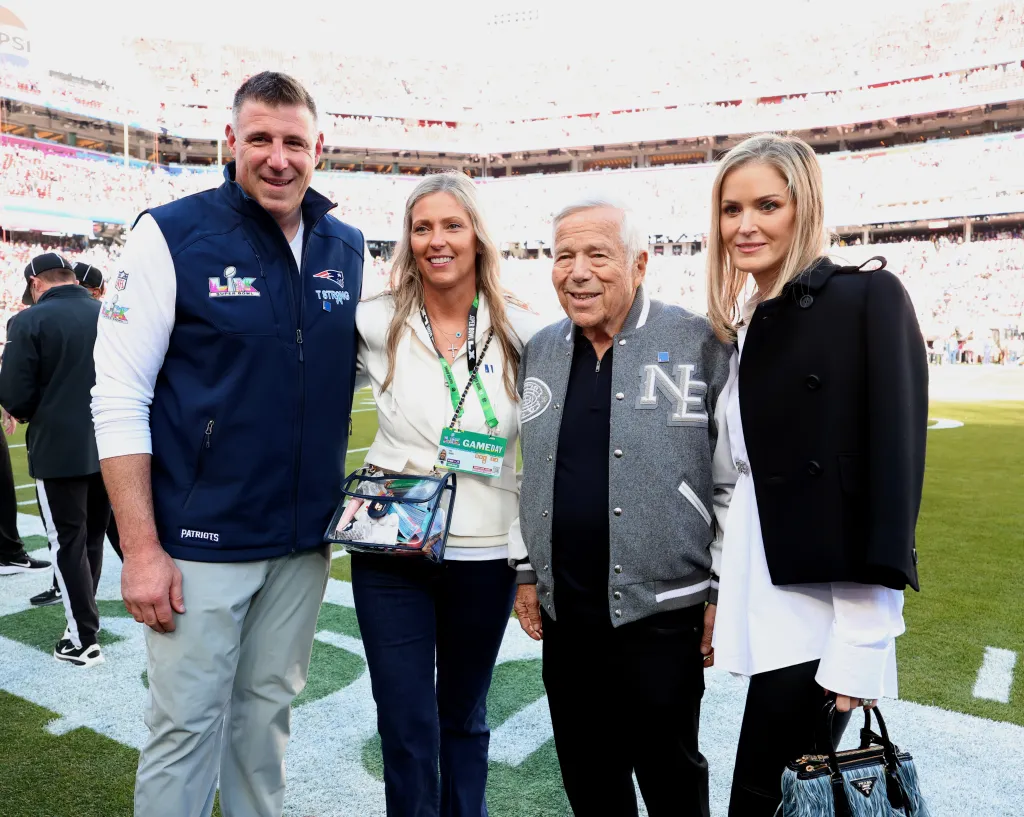 Mike Vrabel, Jen Vrabel, Robert Kraft, and Dana Blumberg pose together on a football field during the Super Bowl LX Pregame.