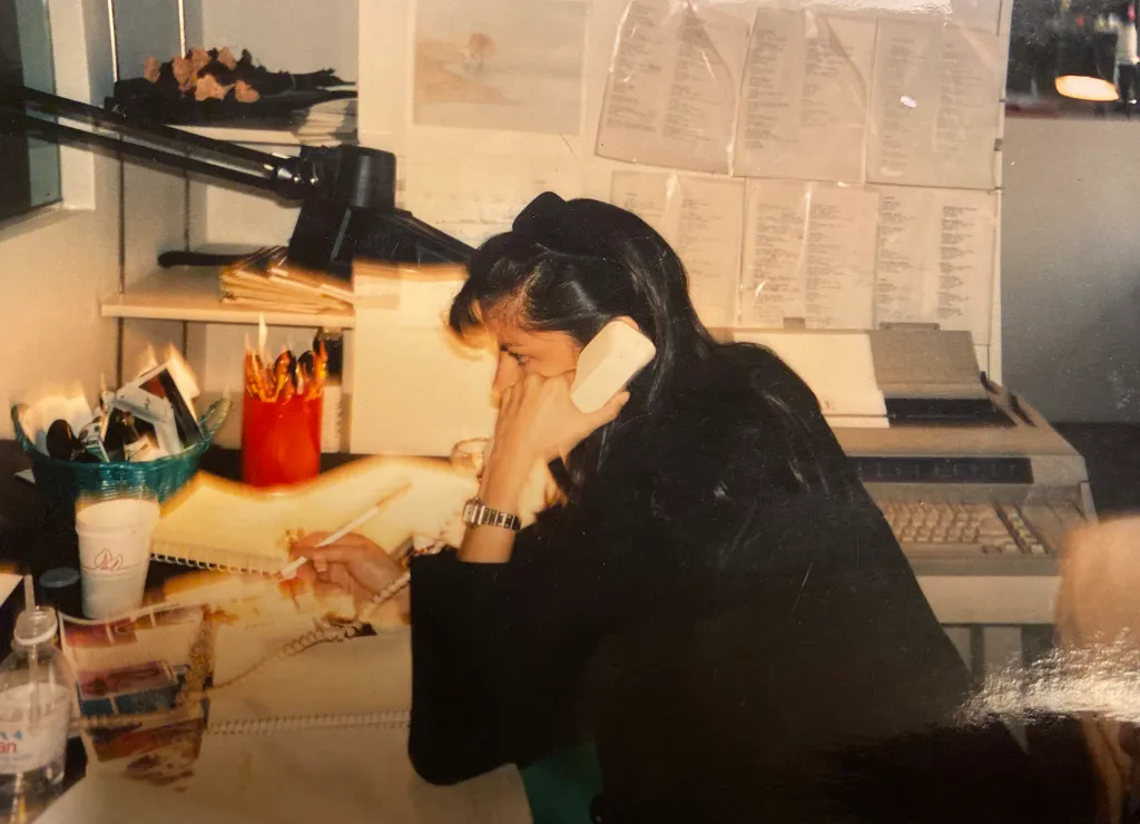 Jenny Syquia working at Vogue, on the phone at her desk.