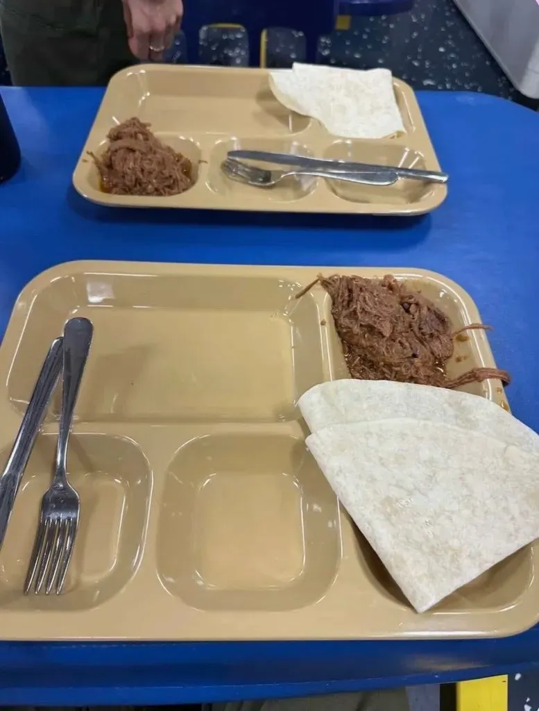 Two trays of shredded meat and tortillas, with cutlery.