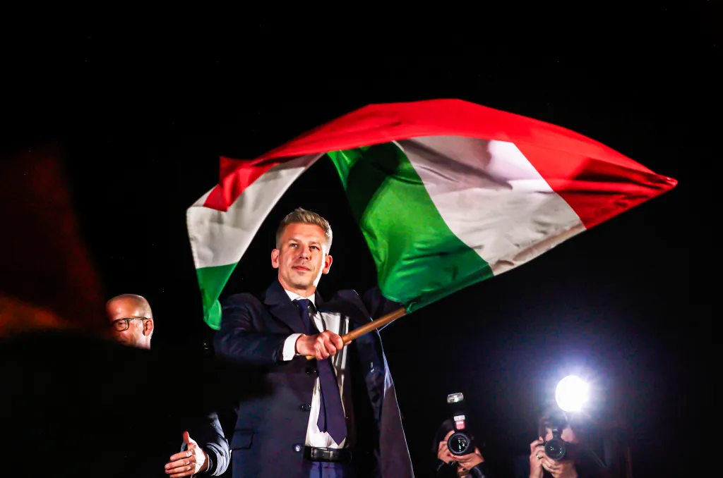 Peter Magyar waves a Hungarian flag after his victory speech.