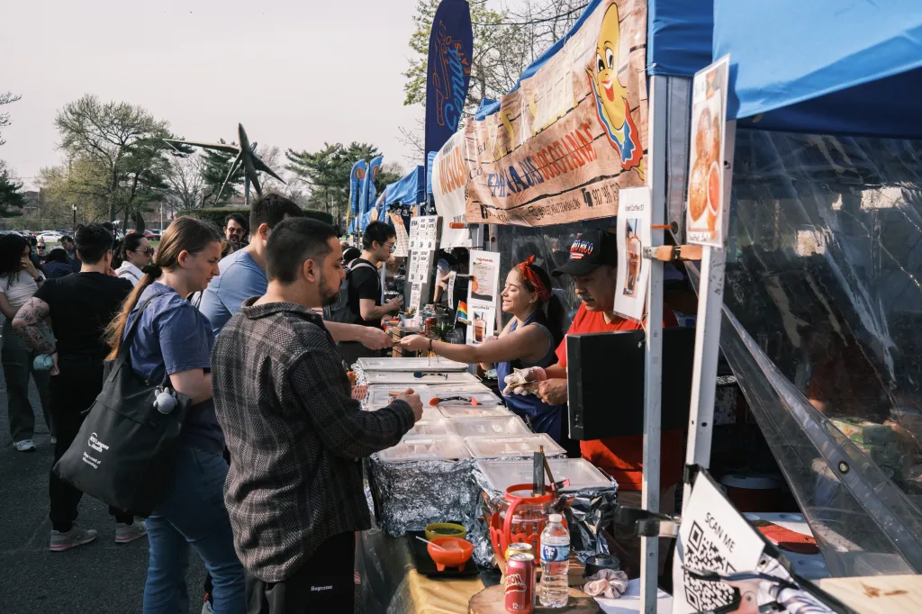 People lining up at food stalls at the Queens Night Market.