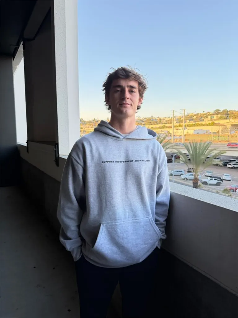 A young man in a grey hoodie with 