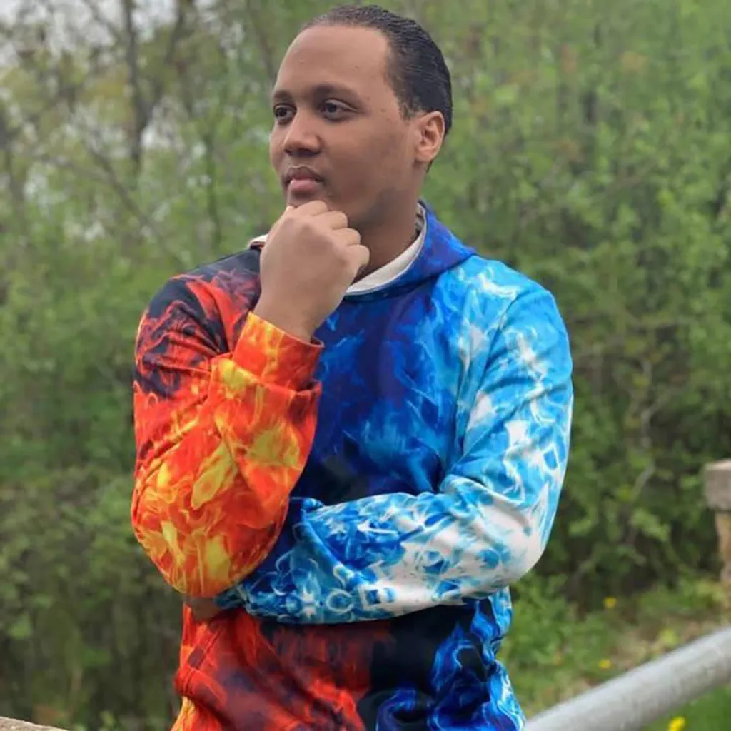 Omni Maxx Morningstar in a hoodie with a blue and red flame pattern.