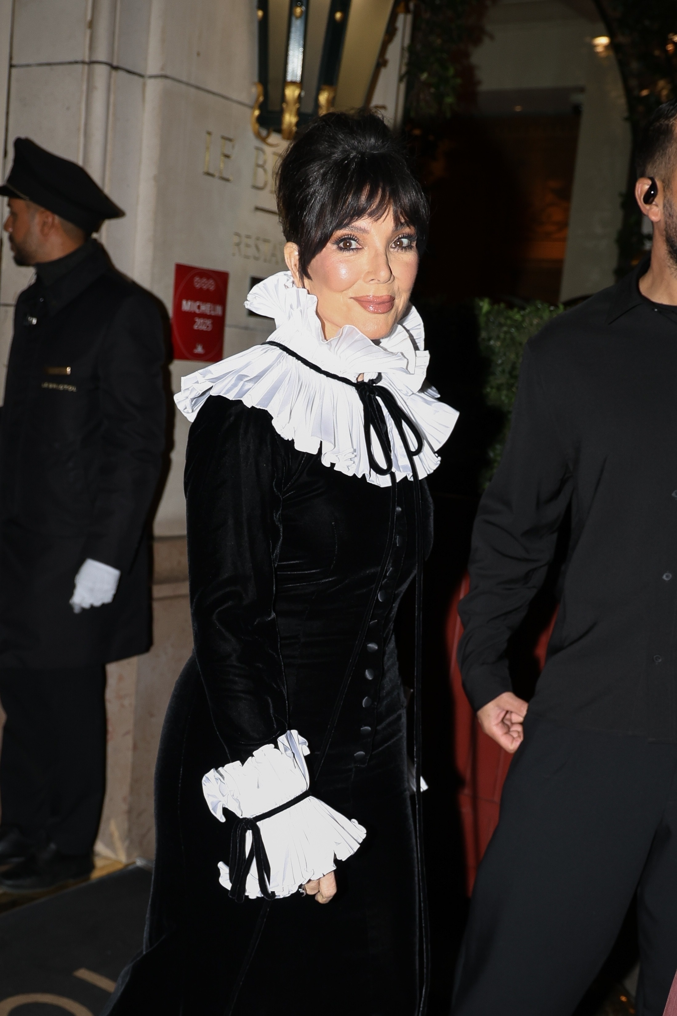 Kris Jenner in a black Oscar de la Renta gown with a ruffled white collar and cuffs, at the All's Fair Paris Premiere.