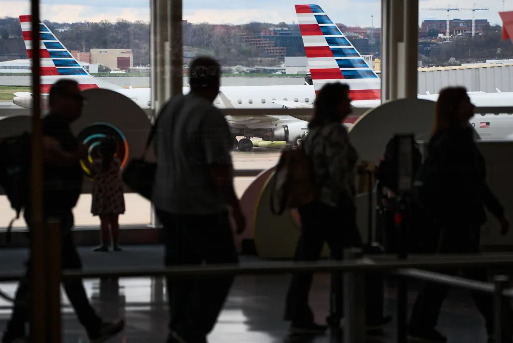 Passengers walk past American Airlines planes at Ronald Reagan Washington National Airport.