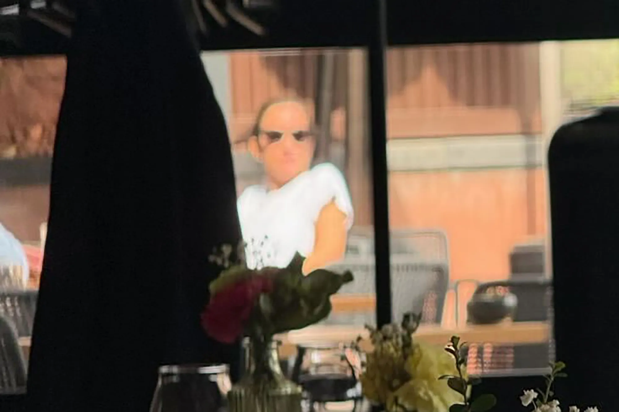 Dianna Russini, wearing sunglasses and a white shirt, seated at a restaurant.
