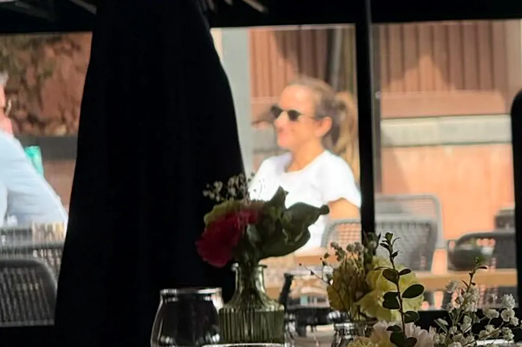 Dianna Russini with her hair in a ponytail and wearing sunglasses, seen in a reflection at a hotel in Sedona, Arizona.
