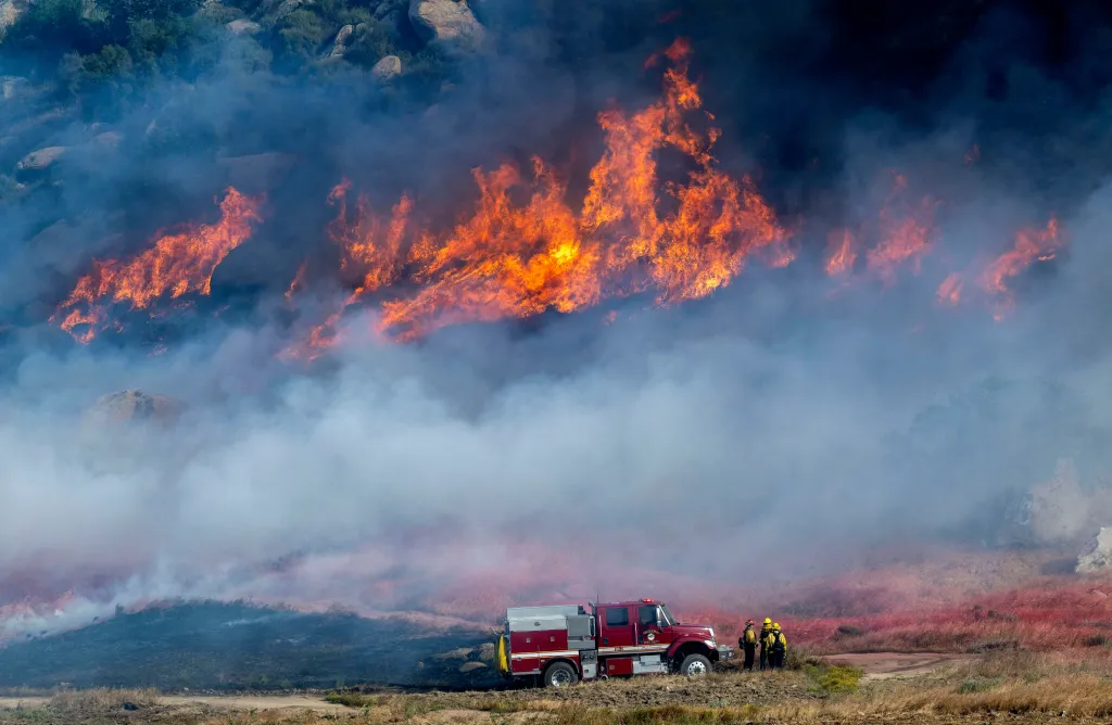 Flames and smoke cover a hillside as crews battle the fast-growing Springs Fire In Moreno Valley, Calif. on April 3, 2026.