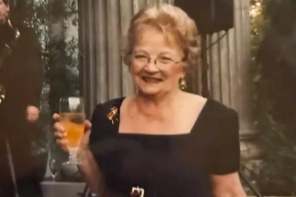Peggy Fields smiling and holding a glass.
