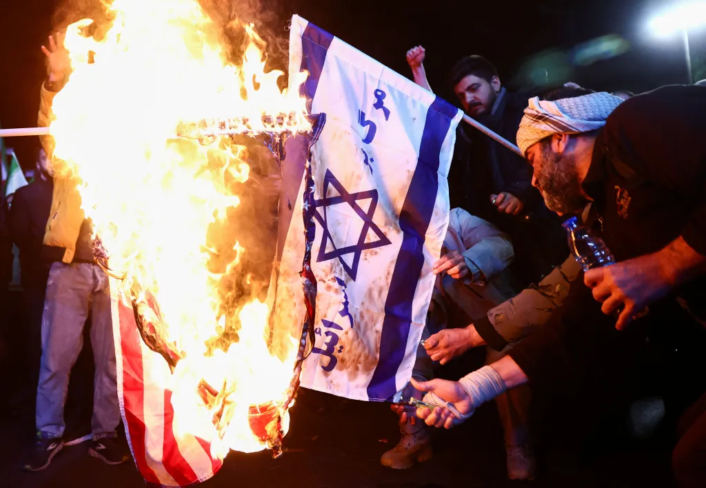 People burn the flags of the U.S. and Israel after a two-week ceasefire in the Iran war was announced, in Tehran.