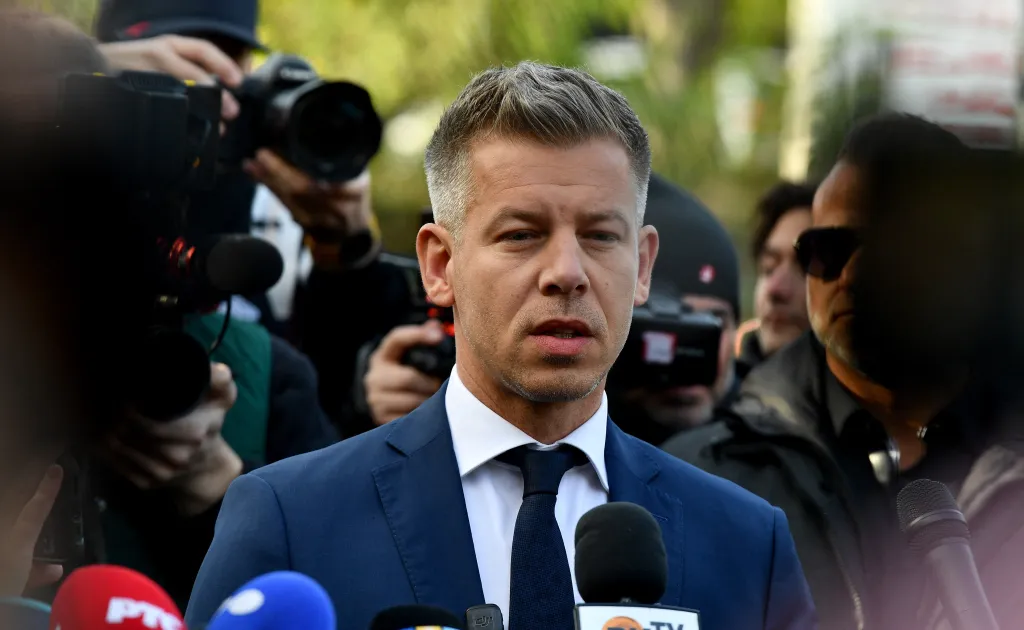 Peter Magyar, leader of the pro-European conservative TISZA party, speaks to journalists with microphones.