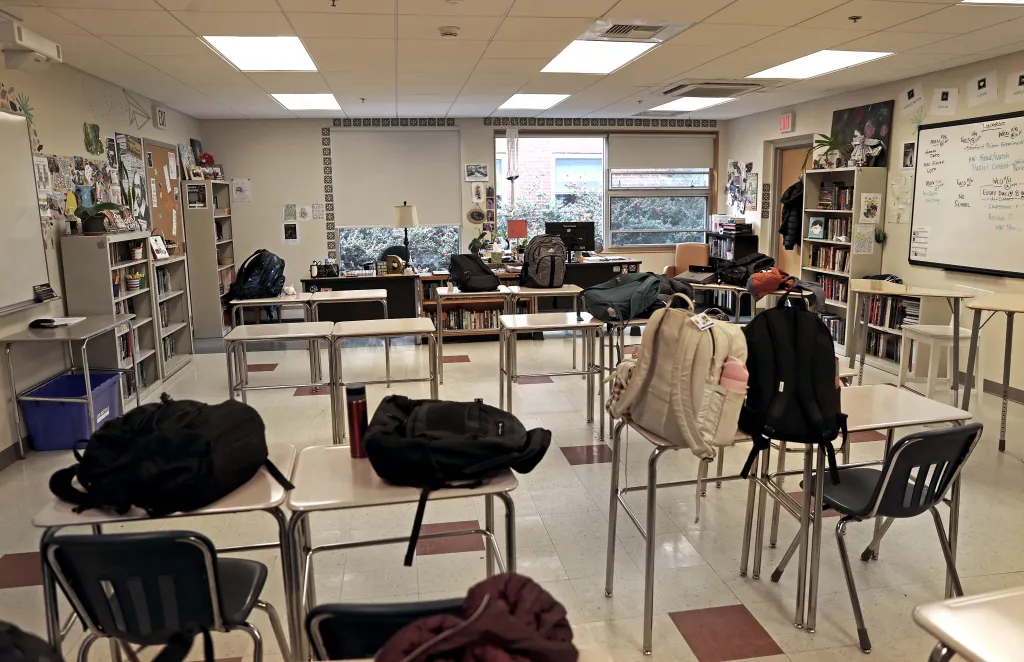 An empty classroom at Lexington High School with backpacks on desks.