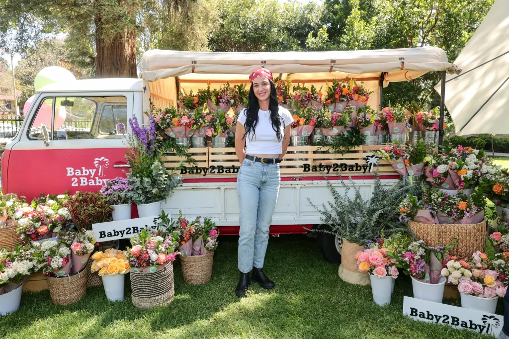 Katy Perry stands in front of a Baby2Baby flower truck.