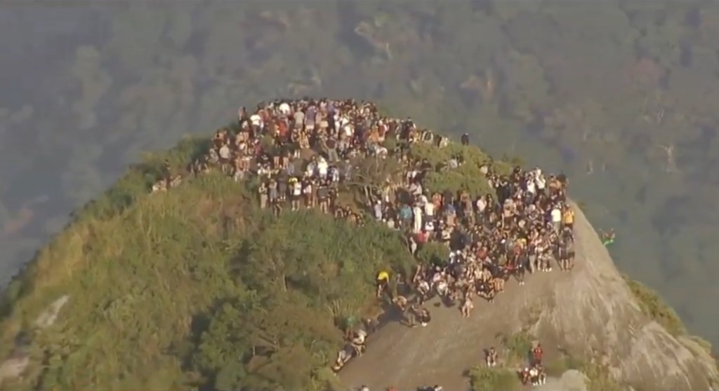 Tourists shelter atop Morro Dois Irmaos as a shootout rages below on April 20, 2026.