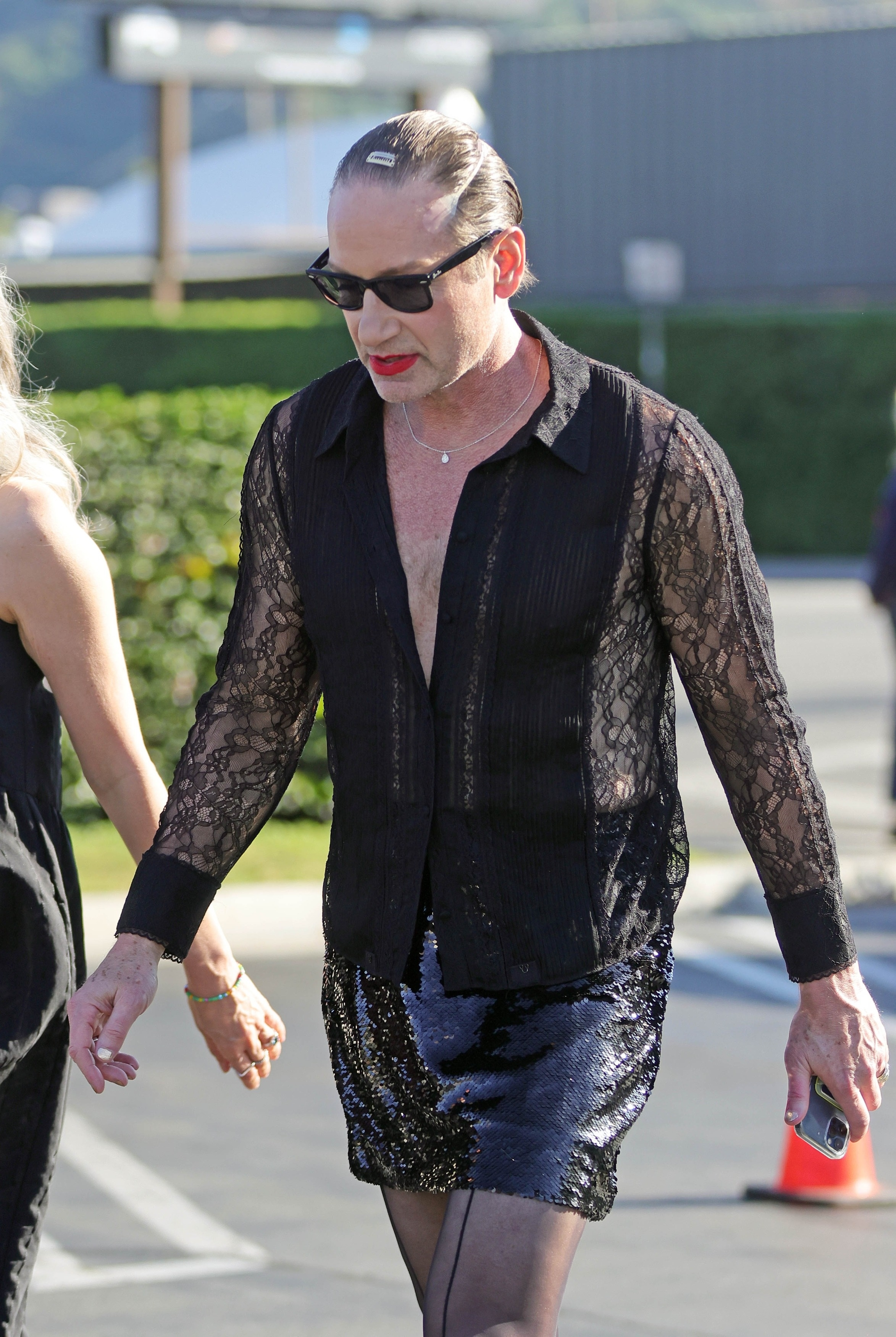 David Duchovny dressed as a woman, wearing a black lace shirt, a sequined skirt, and red lipstick, while filming for the movie