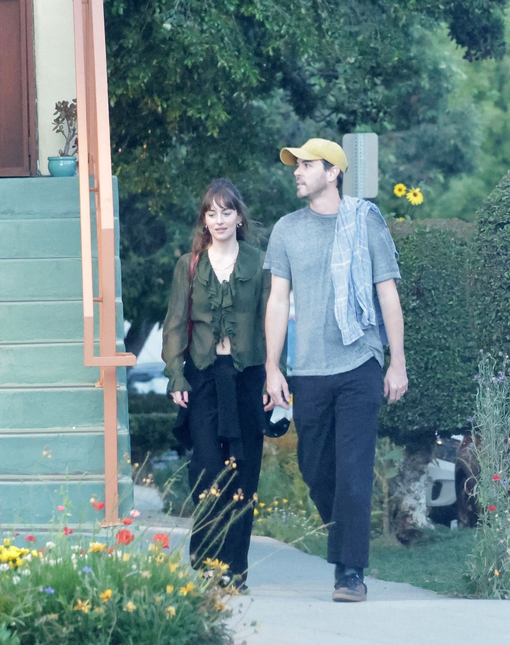 Dakota Johnson and Role Model walking together outdoors.