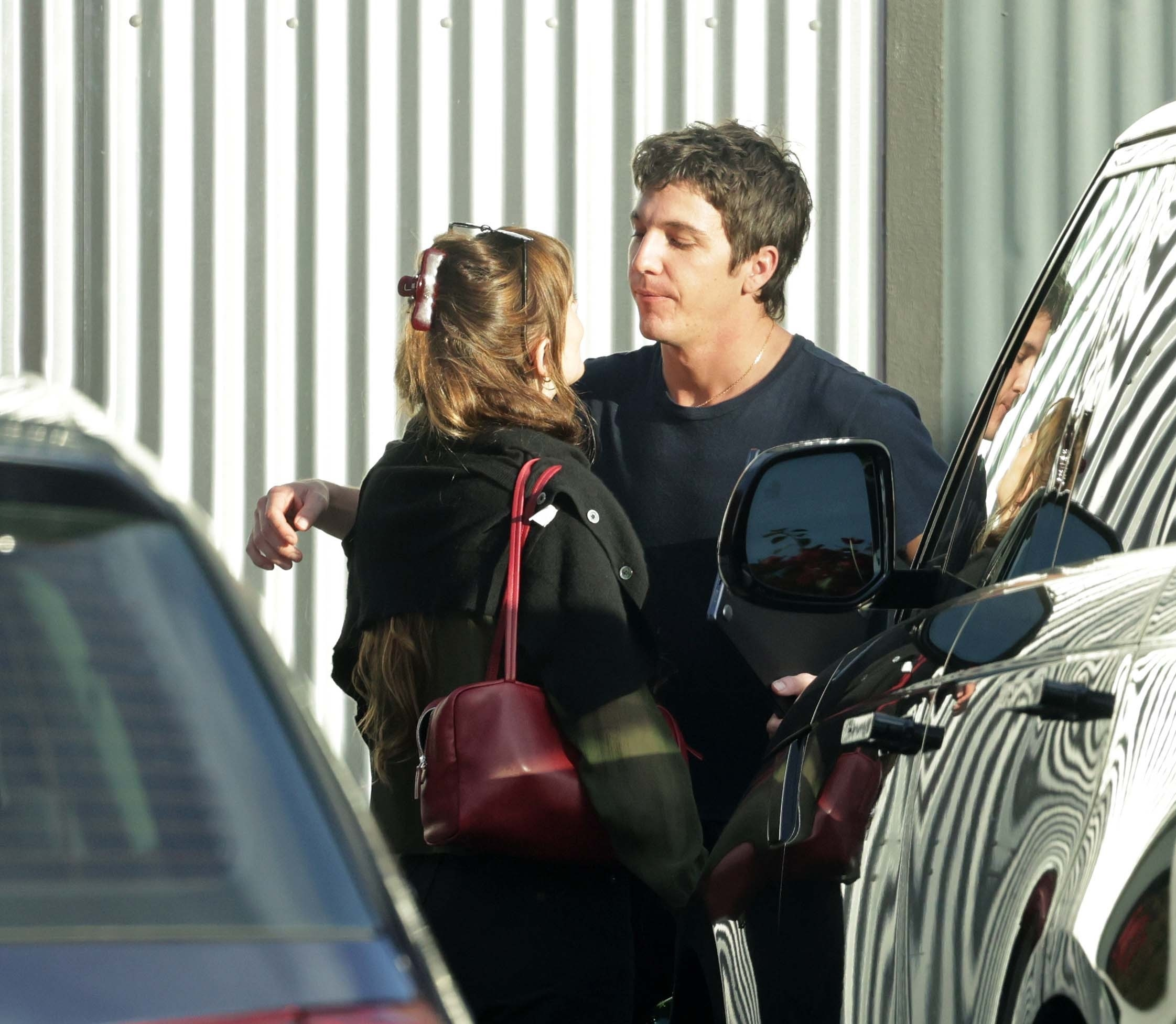 Dakota Johnson and Role Model in an intimate conversation next to a car.
