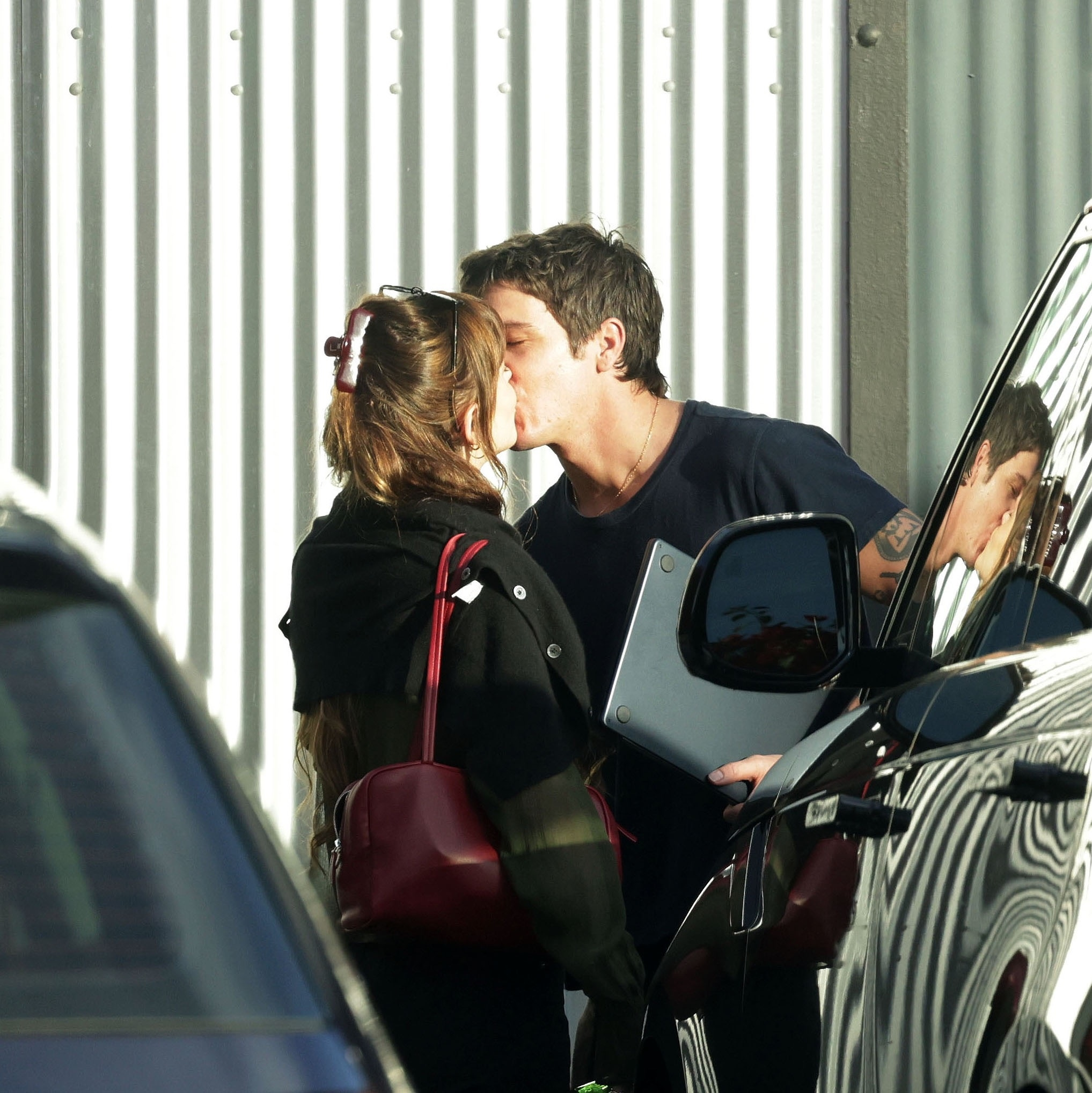 Dakota Johnson and Role Model sharing a kiss outdoors.