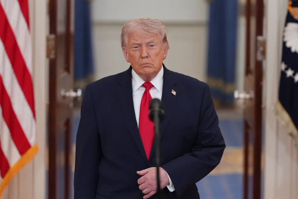 President Donald Trump at a podium in the Cross Hall of the White House.