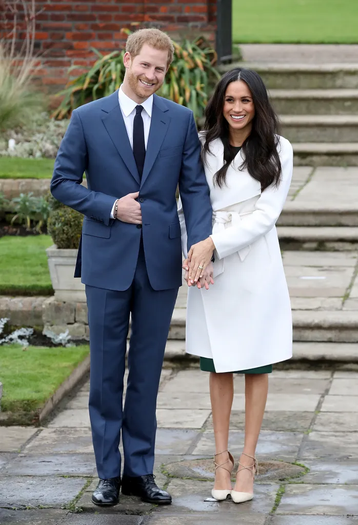 Prince Harry and Meghan Markle announcing their engagement, holding hands and smiling at the camera.