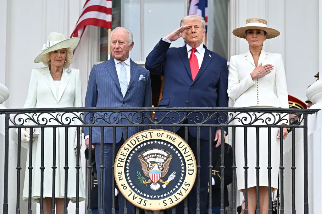 King Charles III, Queen Camilla, President Donald Trump, and First Lady Melania Trump stand on a balcony.