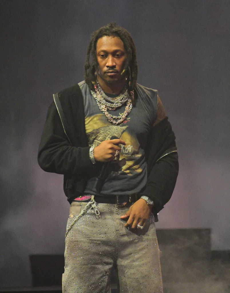 Rapper Future performs onstage wearing a black jacket, a gray t-shirt, and sparkly gray pants.