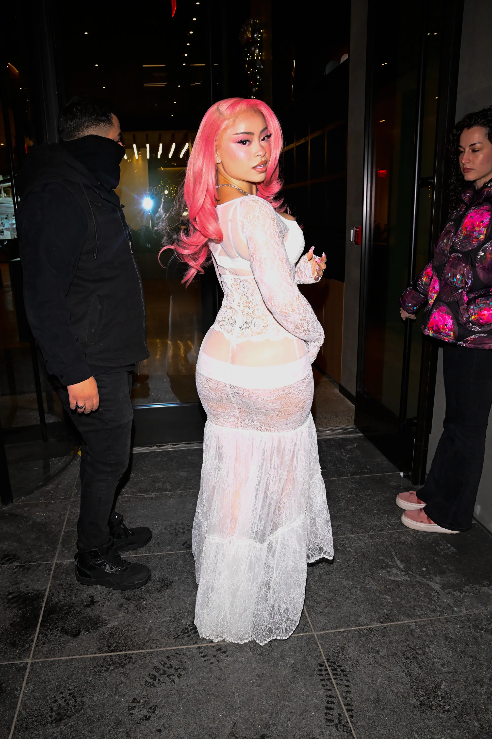 Rapper Ice Spice in a white lace dress with pink hair.