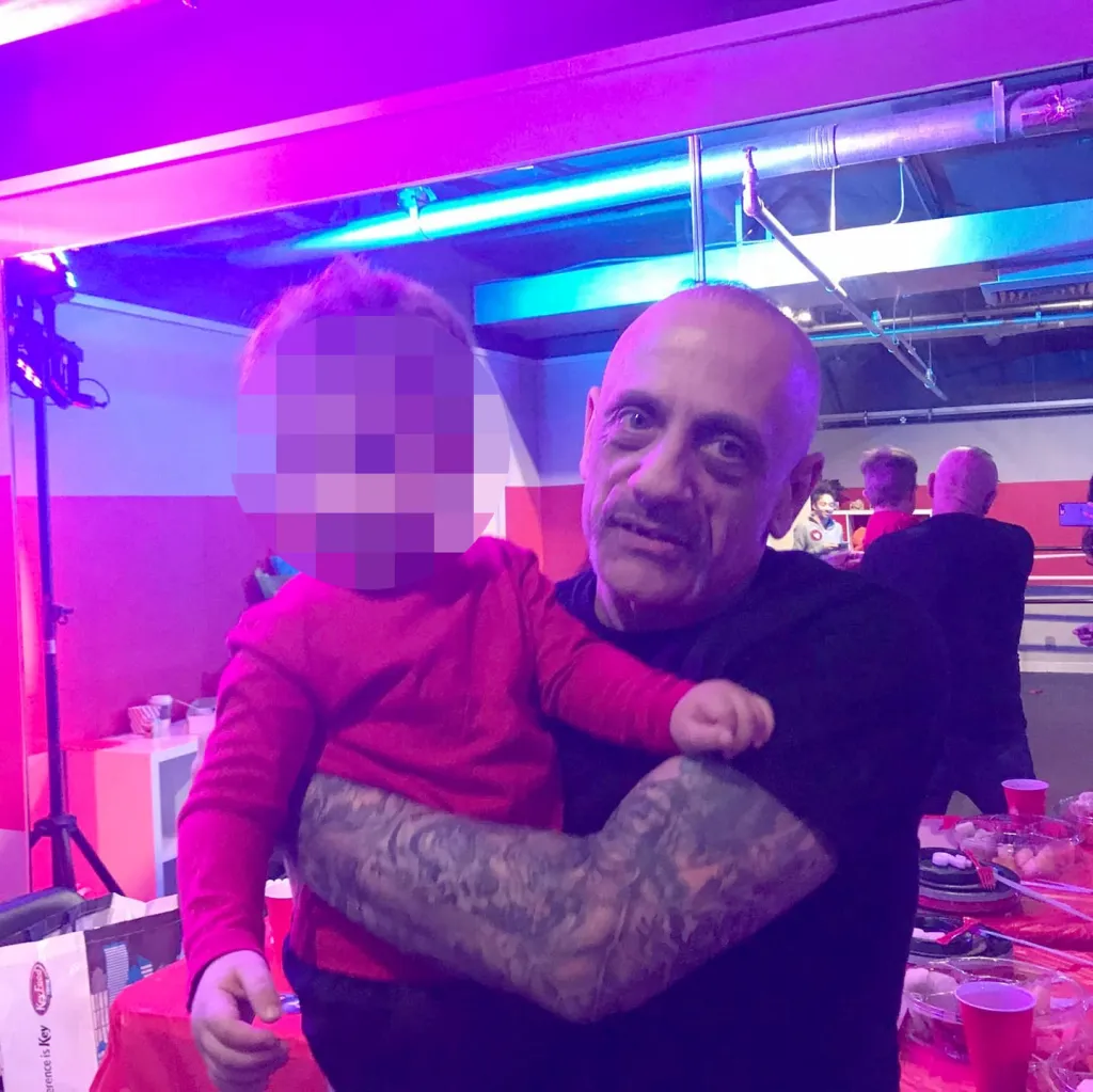 Raymond Elders holding a young child.