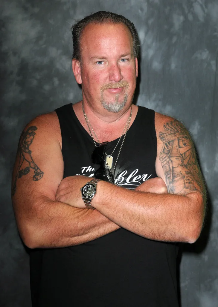 Darrell Sheets, a reality TV star, in a black sleeveless shirt with tattooed arms crossed, looking at the camera.