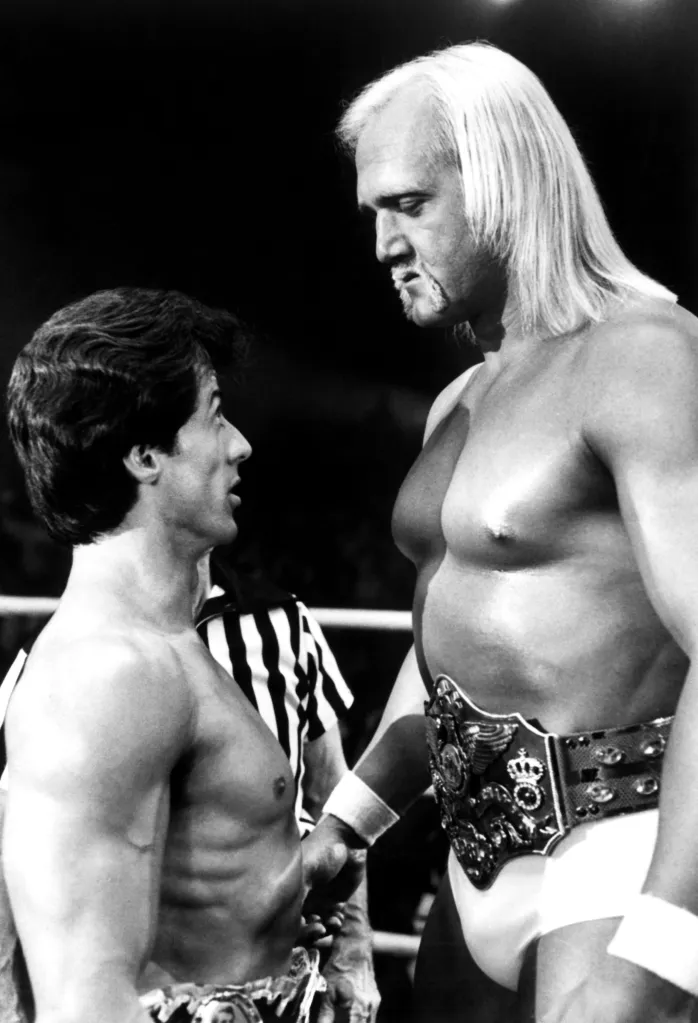 Black and white photo of Sylvester Stallone and Hulk Hogan facing each other in the wrestling ring during a scene from Rocky III.