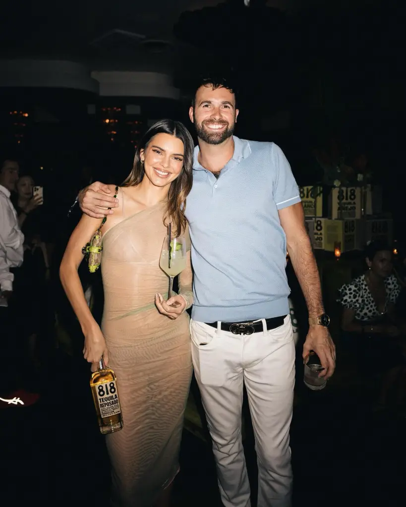 Kendall Jenner and Ronald Gladden smiling at the camera, with Jenner holding a bottle of her 818 Tequila.