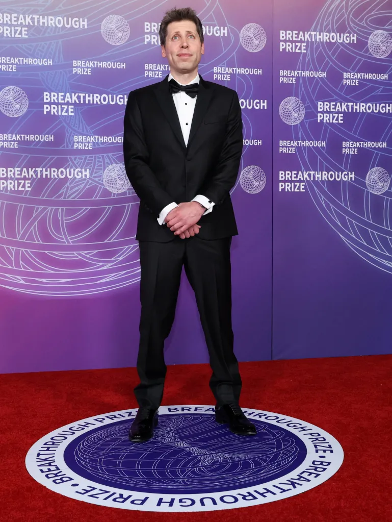 Sam Altman in a black tuxedo on a red carpet with a purple and white 