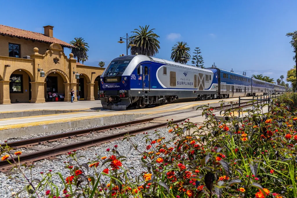 A blue and silver Pacific Surfliner train is parked at the Santa Barbara train station.