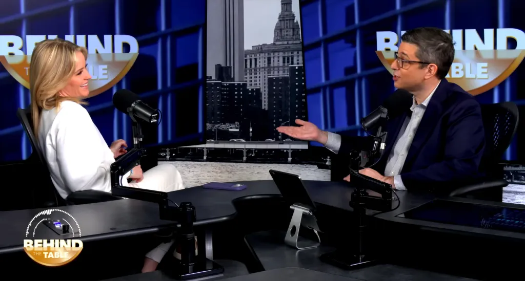 Sara Haines and a man in a dark suit discuss women's family status at a table with microphones.