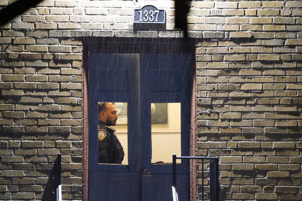 A police officer standing at the door of 1337 Beach Avenue in the Bronx.