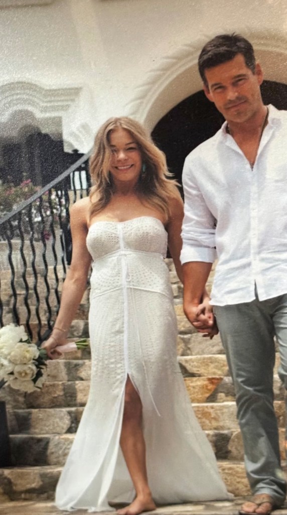LeAnn Rimes and Eddie Cibrian holding hands, walking down stone steps.