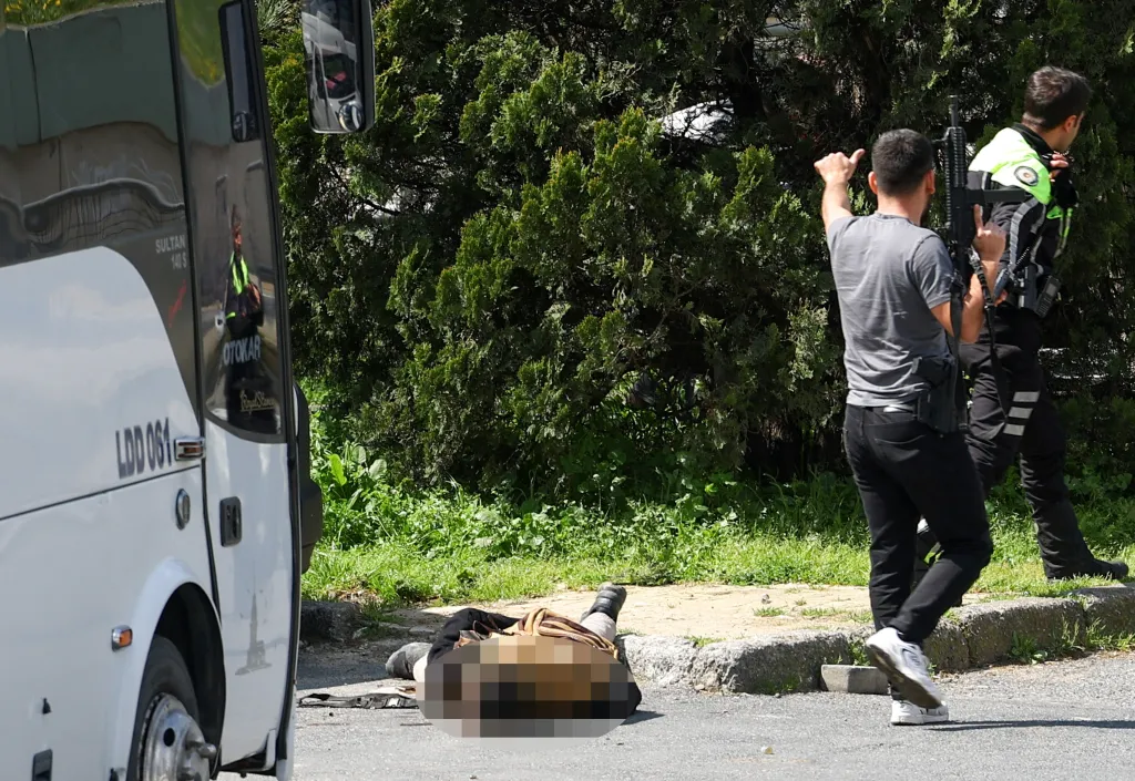 Police stand next to the body of a person believed to be an attacker after gunfire near the Israeli consulate in Istanbul.