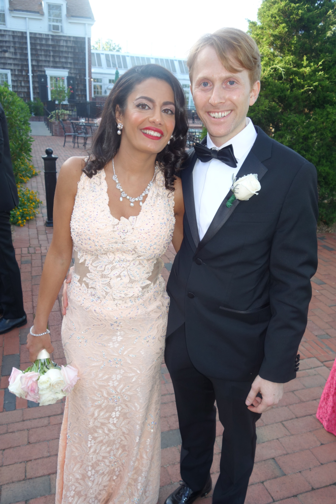 Seterah Bral and Dr. Ryan Aronin smiling at the camera, Bral holding a bouquet of flowers.