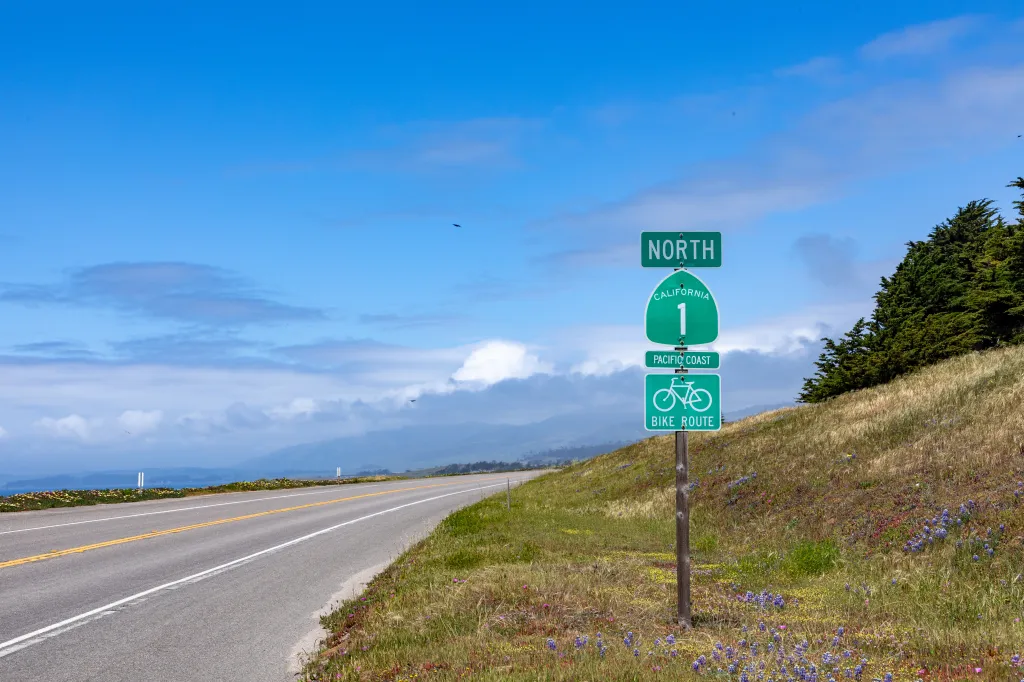 A green sign for California State Route 1 North, Pacific Coast, and a bike route, on Cabrillo Highway.