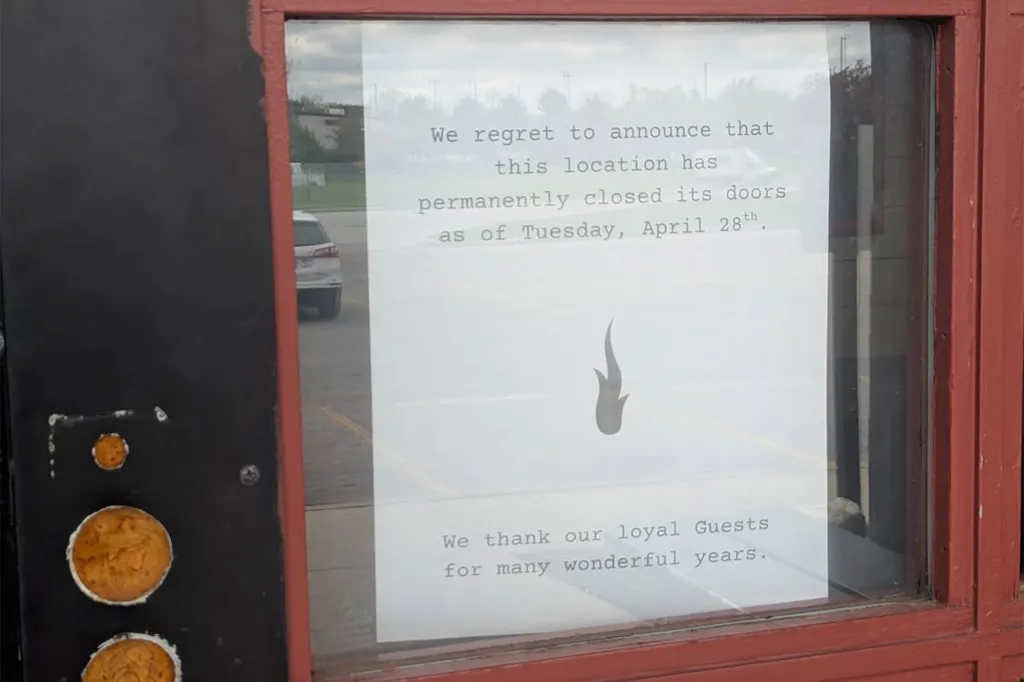 A printed sign in a window announces the permanent closure of a business.