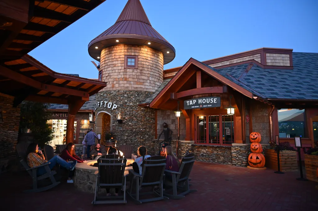 People sitting around a fire pit outside the Tap House at Anakeesta.