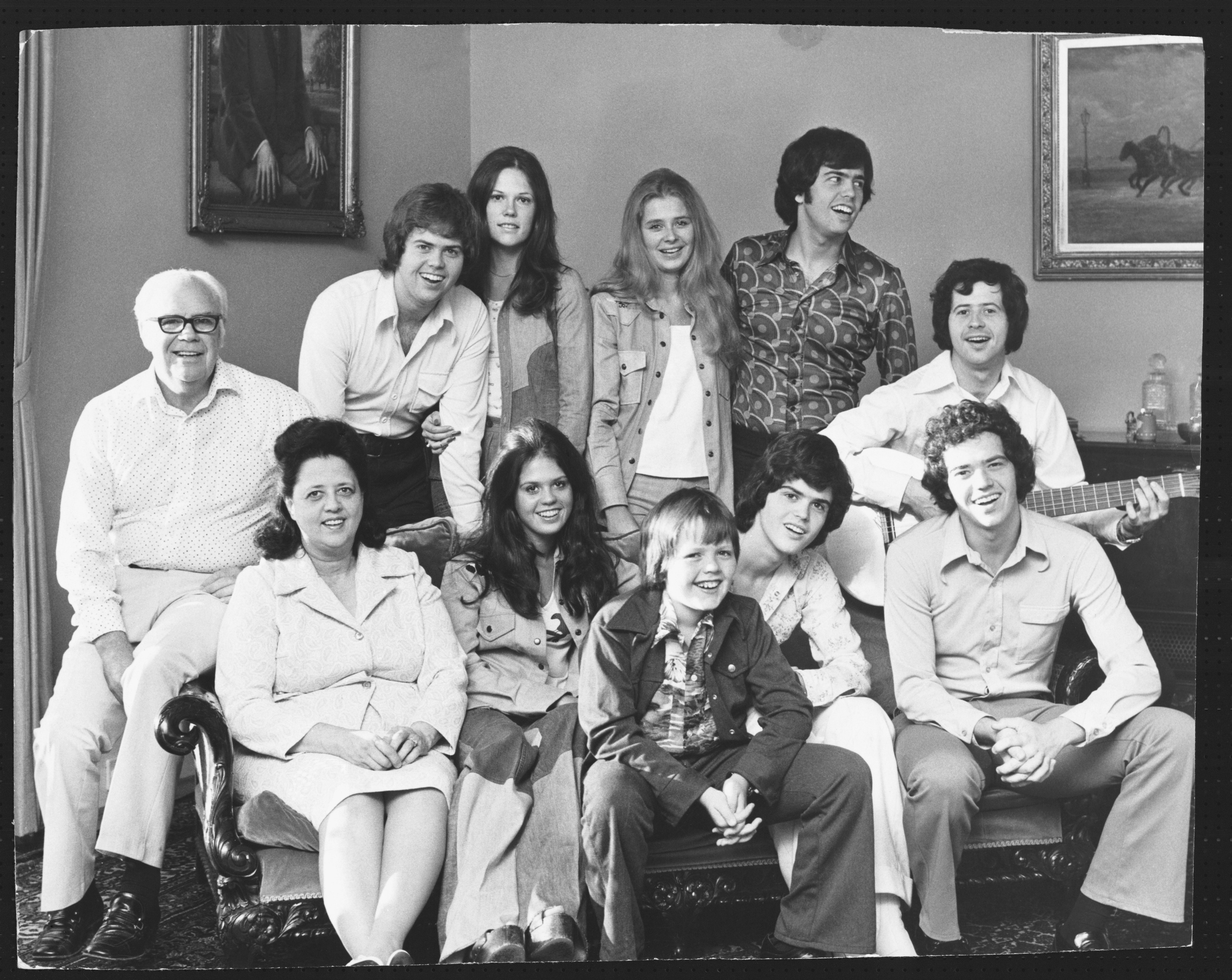 Portrait of the Osmond family, with 12 members seated and standing.