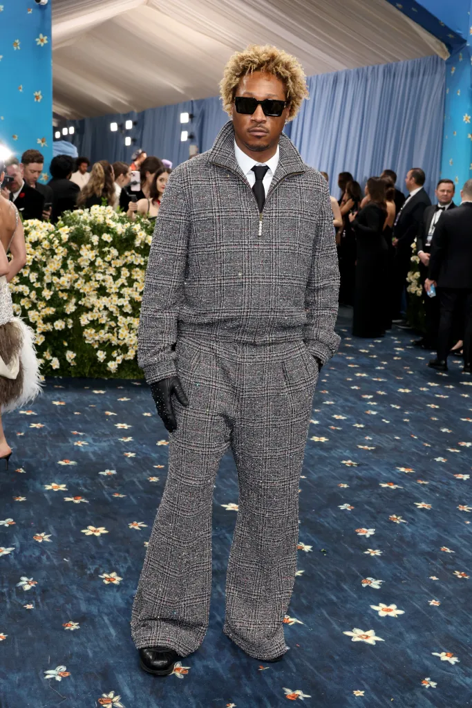 Future attends the 2025 Met Gala wearing a grey and black plaid tracksuit and black sunglasses.