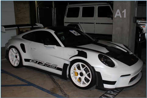 White and black Porsche GT3 RS in a parking garage.