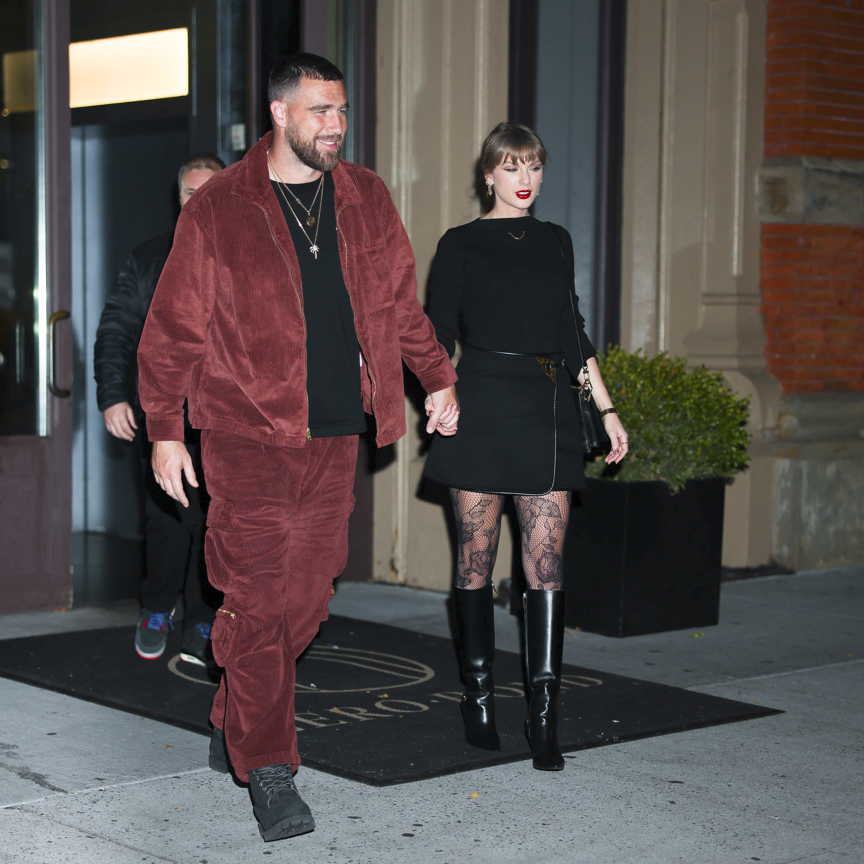 Taylor Swift and Travis Kelce holding hands while walking in New York City.